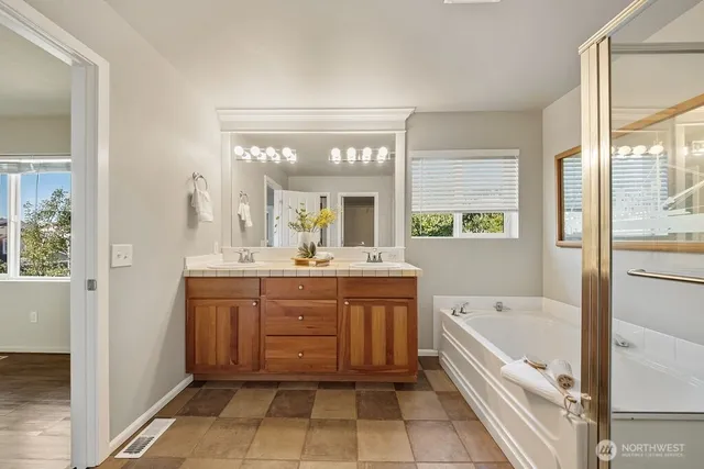 a bathroom with a bathtub sink and mirror