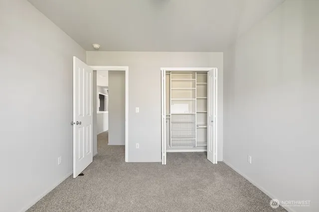 an empty room with closet and a bathroom