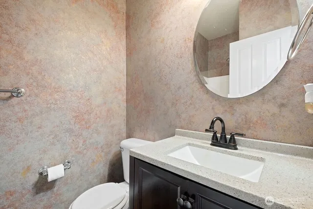 a bathroom with a toilet a sink and mirror