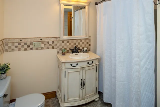 a bathroom with a sink a toilet and shower