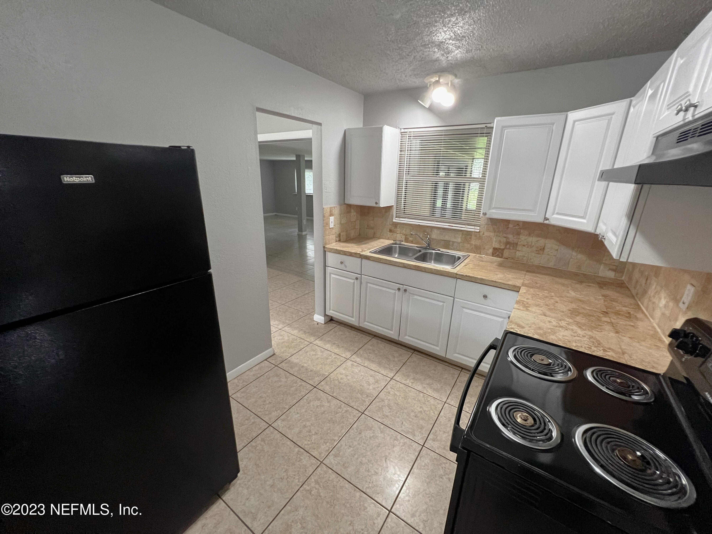 7025 Rollo Road Jacksonville, FL 32205 - Photo 11 of 37 a kitchen with a sink and a refrigerator