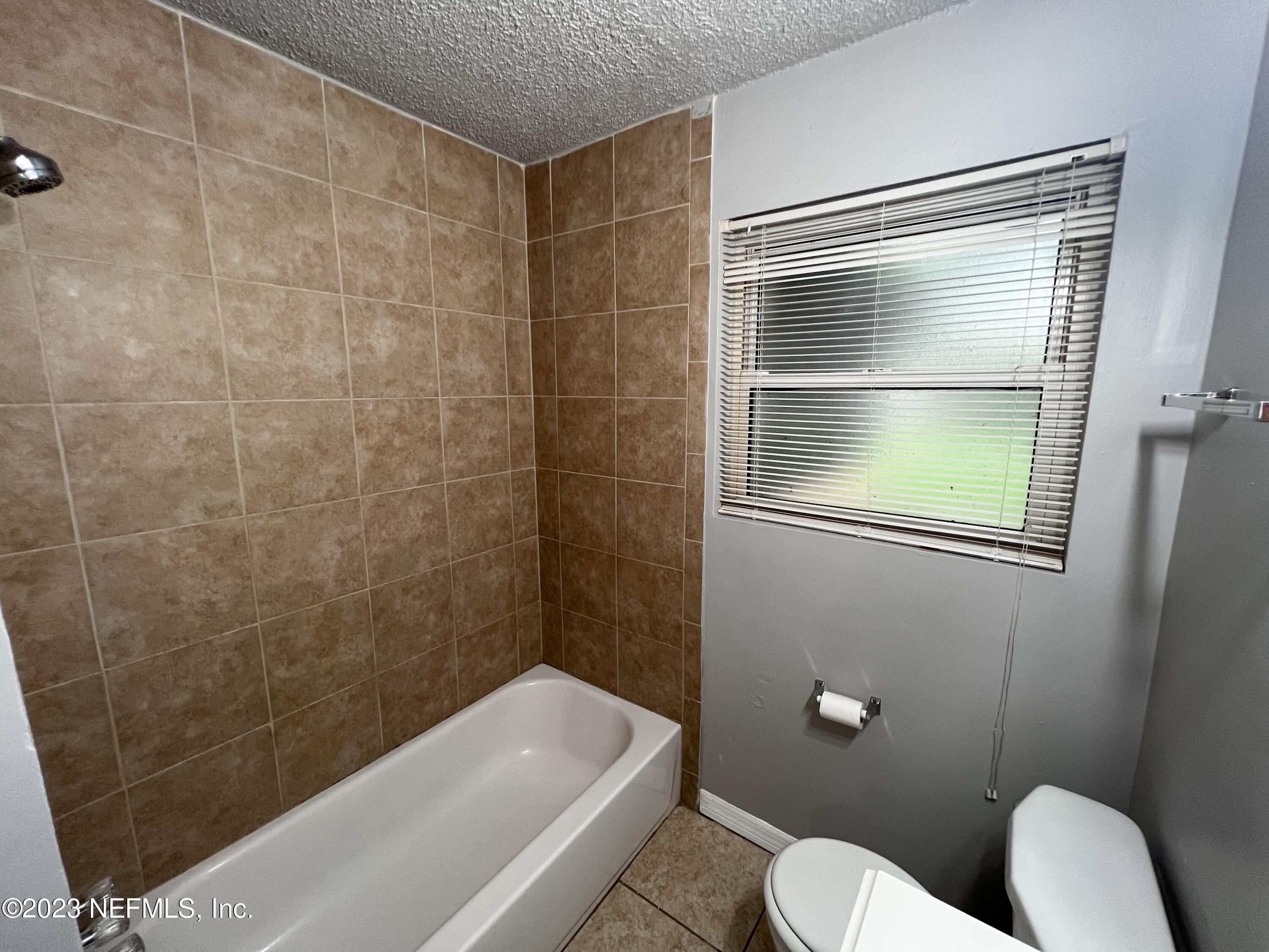 7025 Rollo Road Jacksonville, FL 32205 - Photo 13 of 37 a bathroom with a toilet and a shower