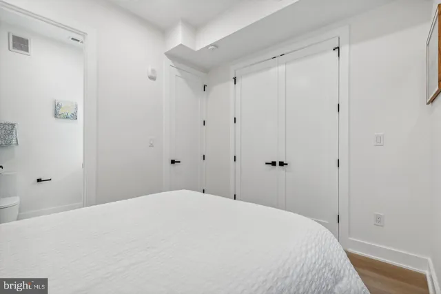a bedroom with a bed and a white cabinet
