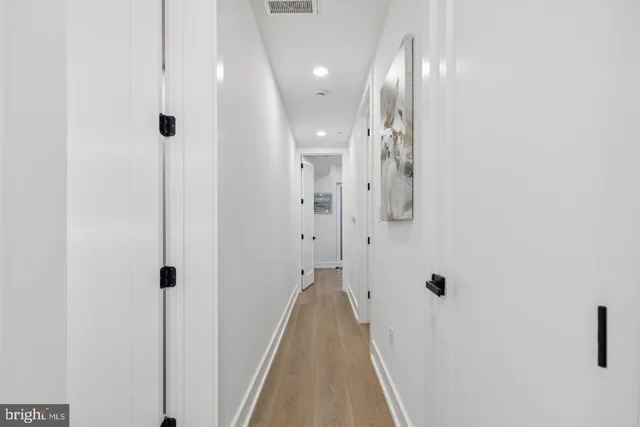 a view of a hallway with wooden floor