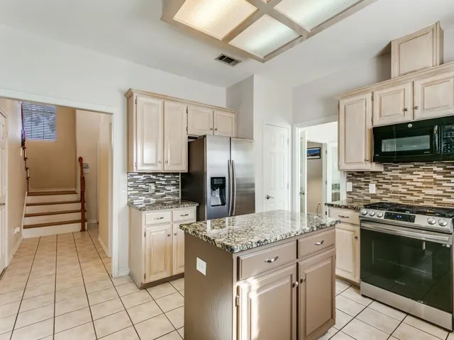 a kitchen with stainless steel appliances granite countertop a stove refrigerator and microwave