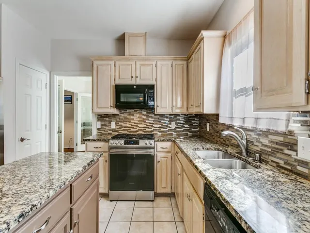 a kitchen with stainless steel appliances granite countertop a sink stove and cabinets