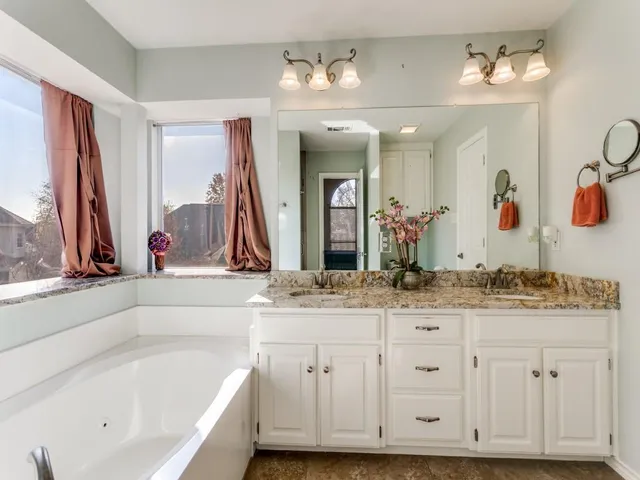 a bathroom with a tub sink and mirror