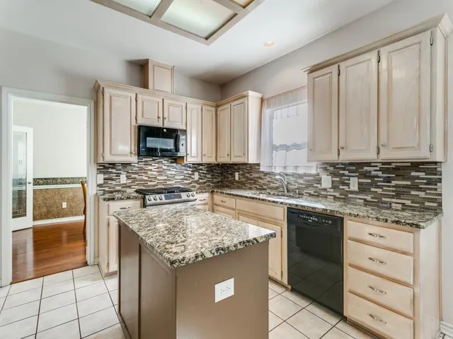 a kitchen with granite countertop a stove sink and cabinets
