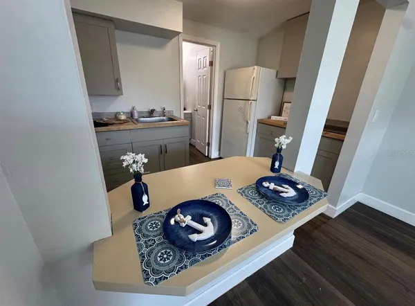 a kitchen with a refrigerator a sink and wooden floor