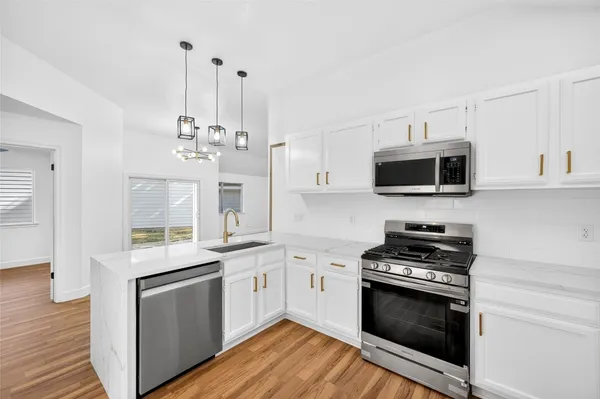 a kitchen with stainless steel appliances a white stove top oven and cabinets