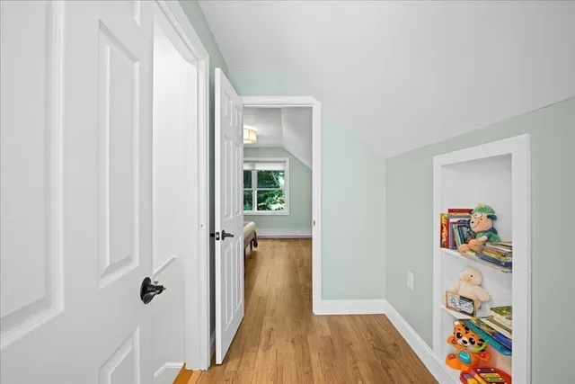 a view of a hallway with wooden floor and closet