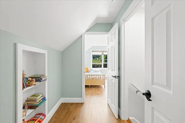 a view of hallway with wooden floor and furniture