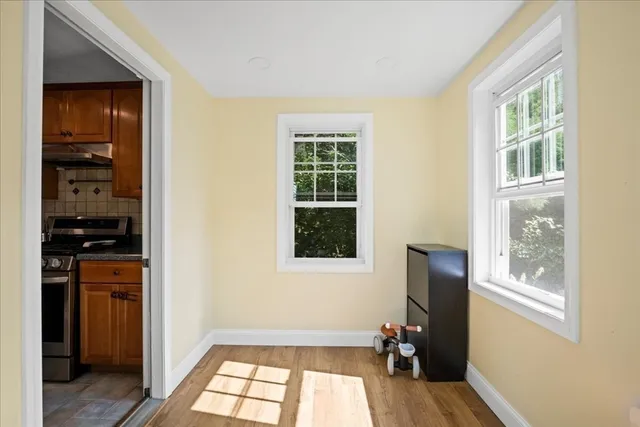 a view of a hallway with wooden floor and windows