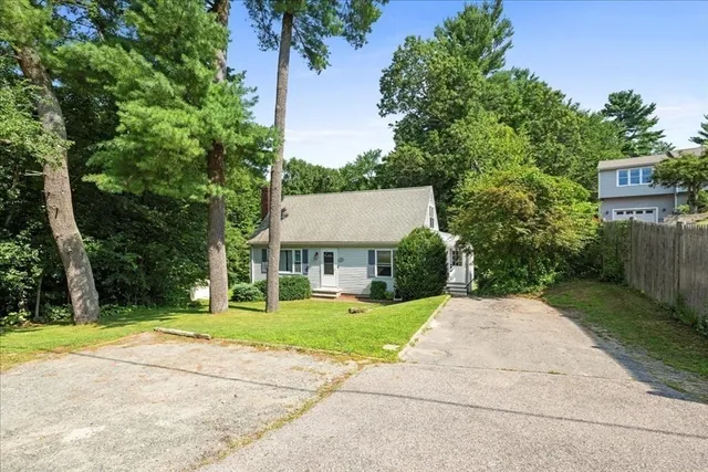 front view of a house with a yard and an trees