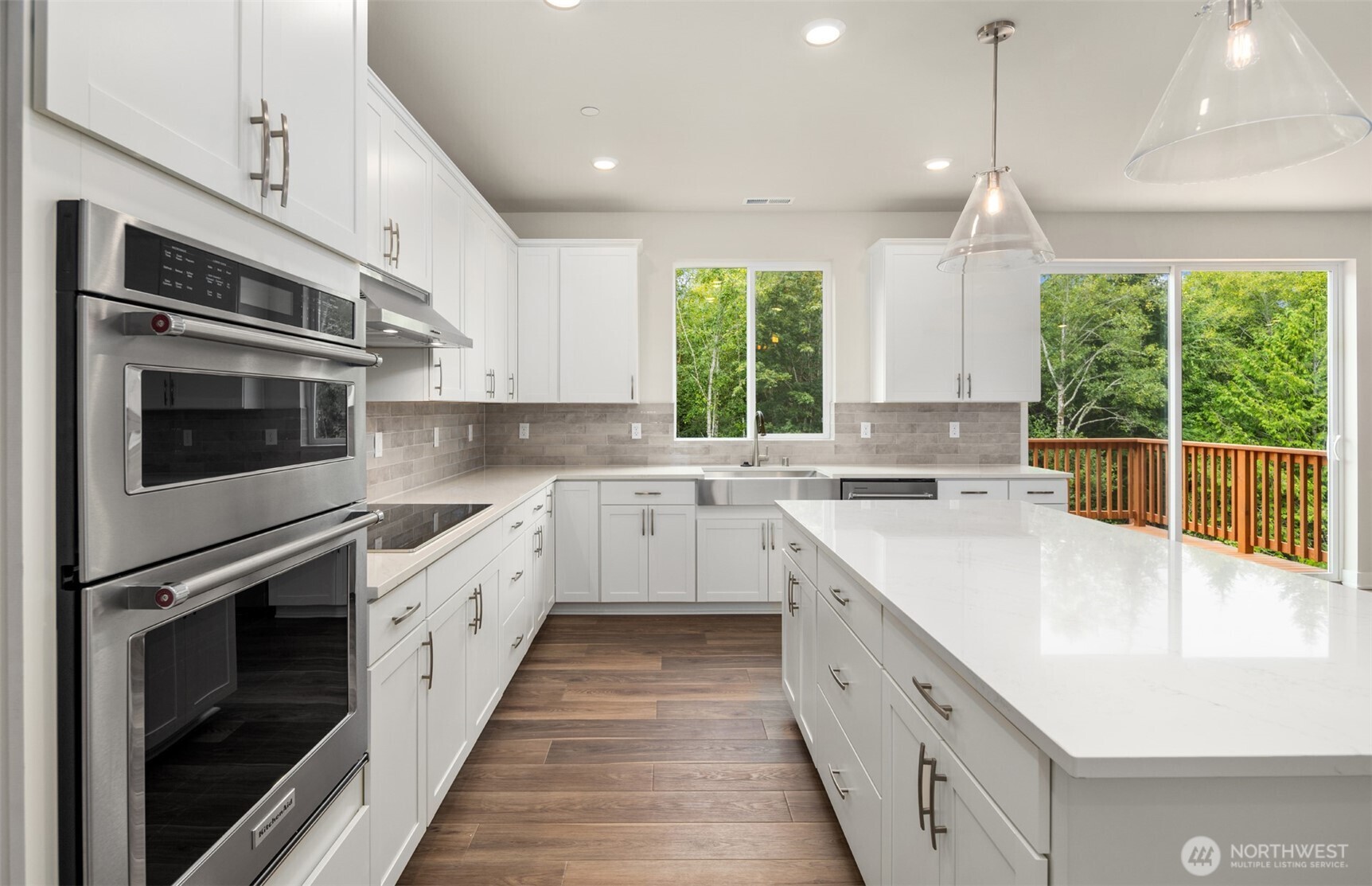 23277 Arbors Ter Road Northeast, Unit 16 Kingston, WA 98346 - Photo 7 of 20 a large white kitchen with stainless steel appliances granite countertop a sink a stove a microwave a counter top and cabinets