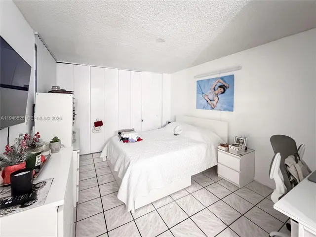 a bedroom with a bed and a potted plant