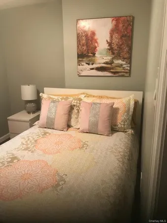 a spacious bedroom with a bed and painting on the wall