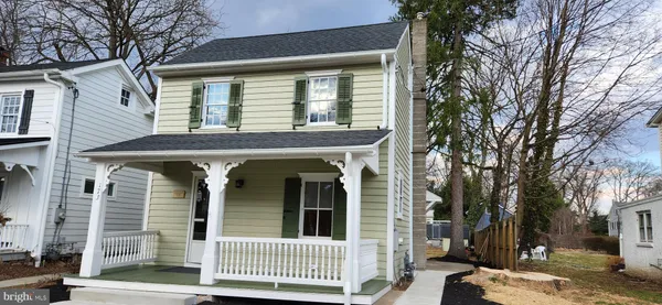 a front view of a house with a tree