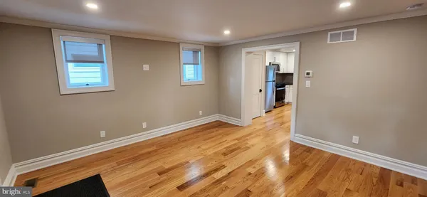 a view of empty room with wooden floor
