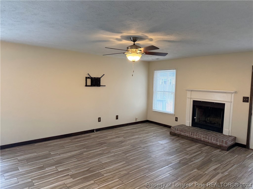 819 Rim Road Fayetteville, NC 28314 - Photo 17 of 42 wooden floor in an empty room with a fireplace