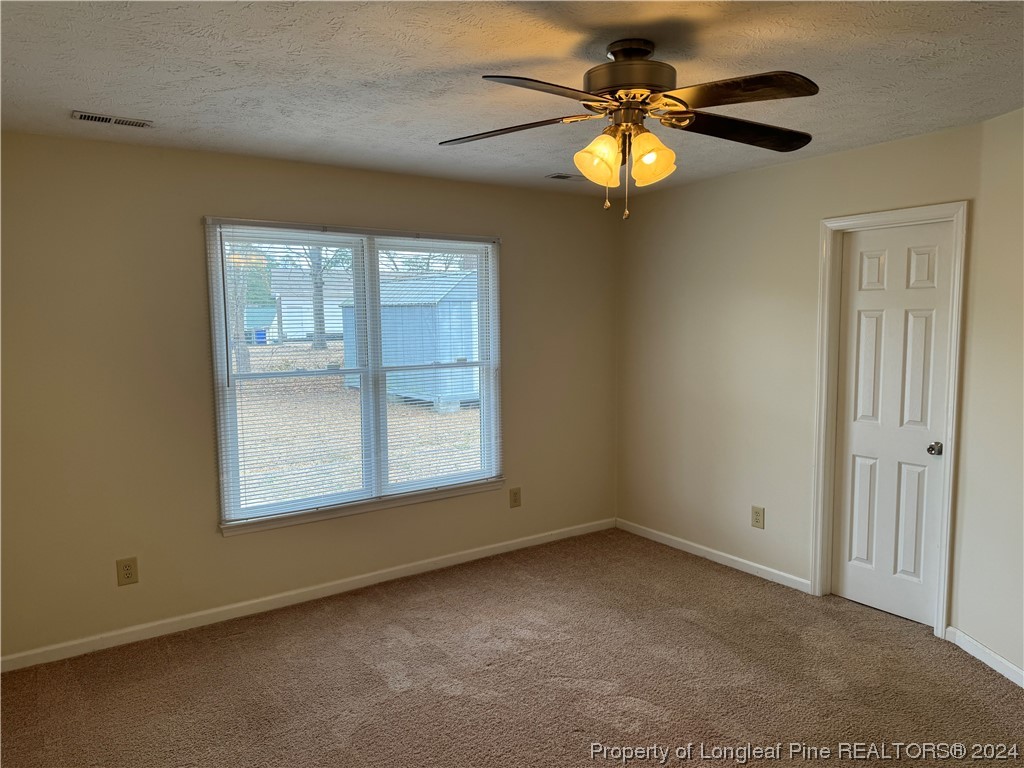 819 Rim Road Fayetteville, NC 28314 - Photo 32 of 42 an empty room with windows and chandelier fan