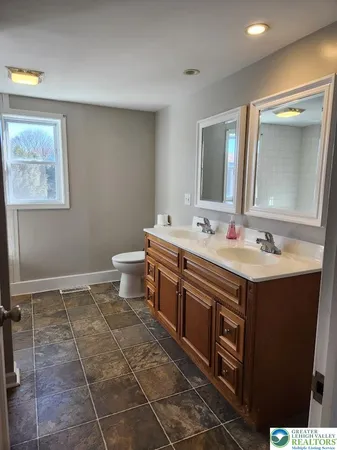 a bathroom with a sink mirror and toilet