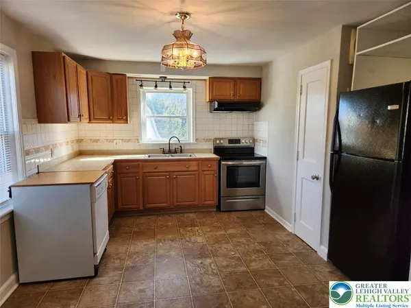 a kitchen with stainless steel appliances a sink stove and refrigerator