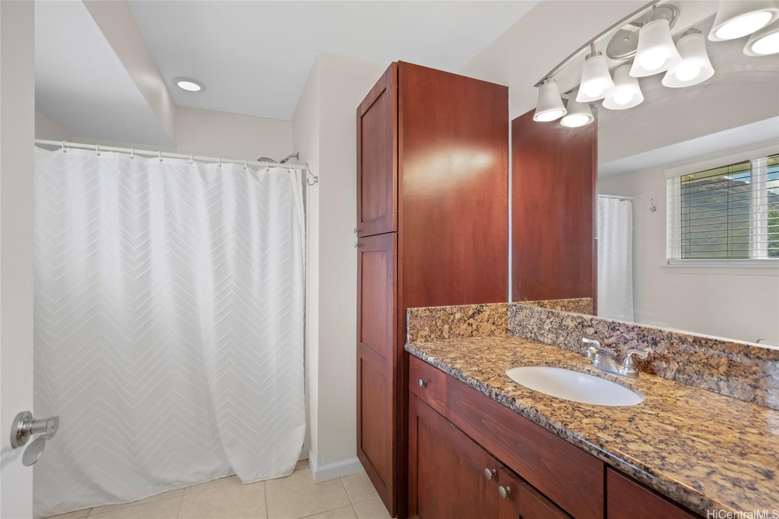 87-176 Maipalaoa Road, Unit D12 Waianae, HI 96792 - Photo 17 of 25 a bathroom with a granite countertop sink and a mirror