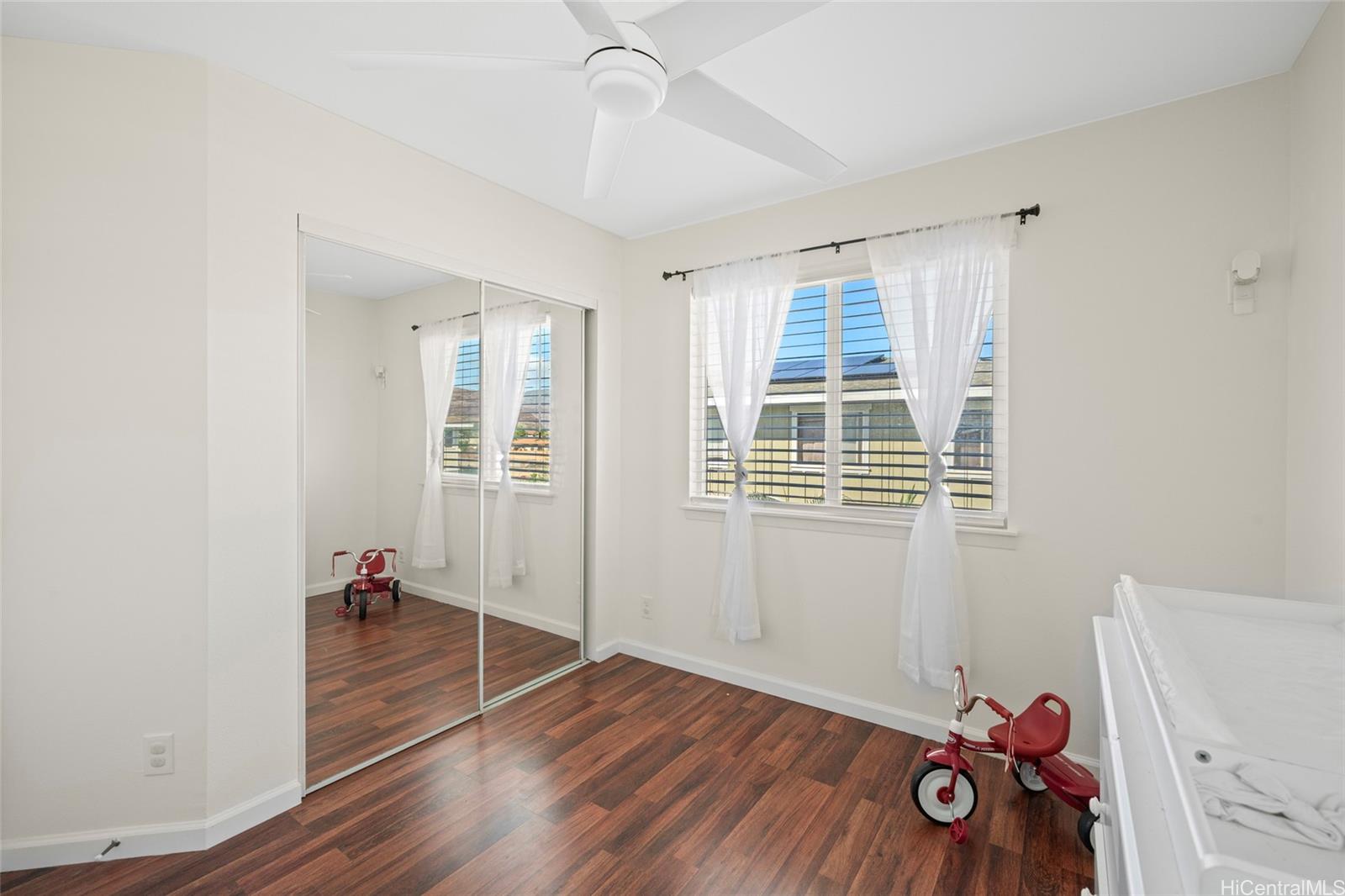 87-176 Maipalaoa Road, Unit D12 Waianae, HI 96792 - Photo 19 of 25 an empty room with wooden floor and windows