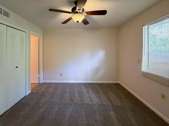 an empty room with a window and a fan