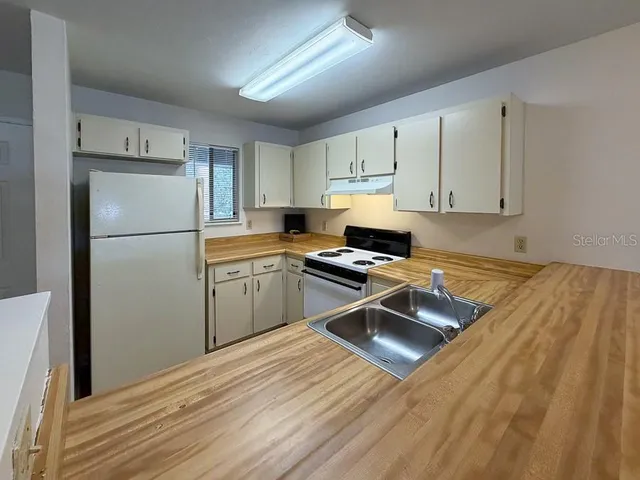 a kitchen with a refrigerator a stove a sink and a cabinets