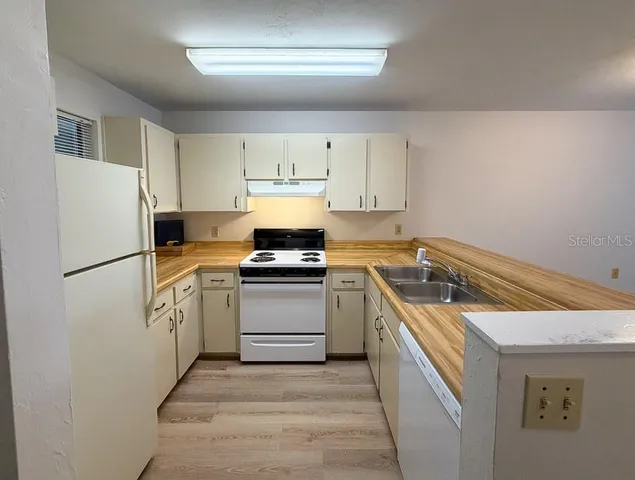 a kitchen with a stove sink and refrigerator