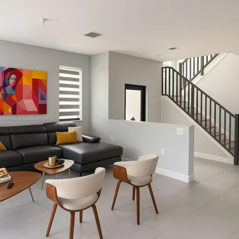 a living room with furniture a rug and a window