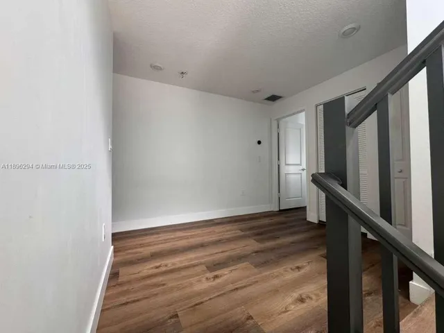 a view of hallway with stairs and wooden floor