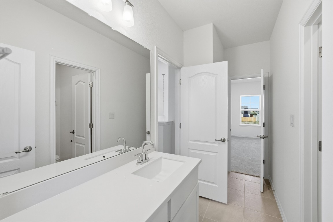 205 Caraway Drive Taylor, TX 76574 - Photo 13 of 15 Bathroom featuring light tile patterned flooring, vanity, and light colored carpet