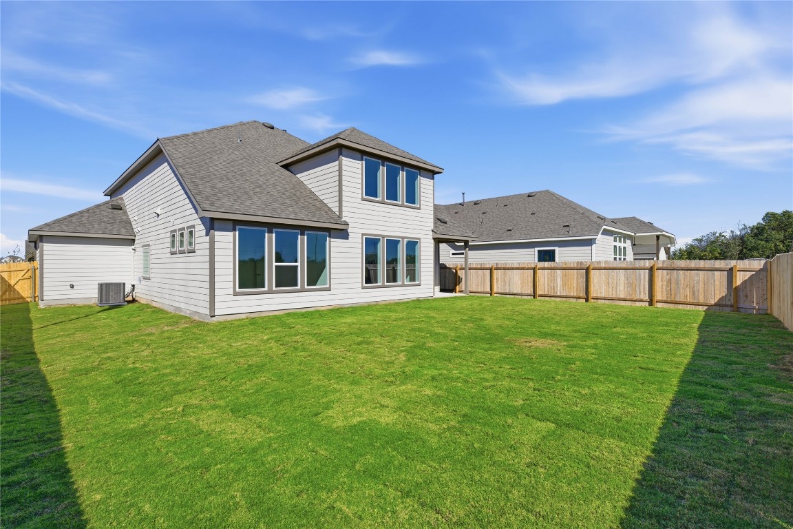 205 Caraway Drive Taylor, TX 76574 - Photo 14 of 15 Rear view of property featuring roof with shingles and a fenced backyard