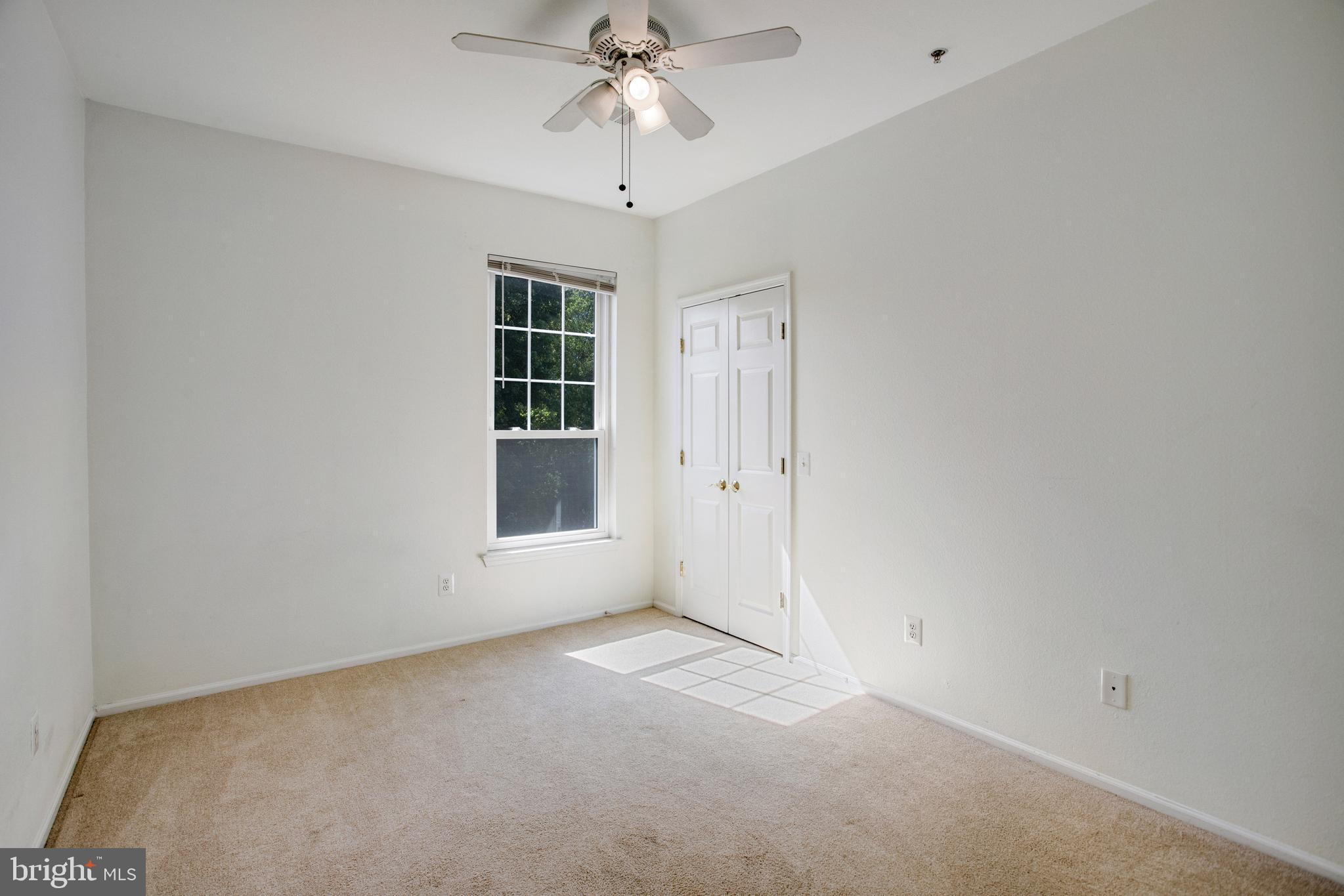 1530 Spring Gate Dr., Unit 9308 McLean, VA 22102 - Photo 22 of 38 an empty room with a chandelier fan and windows
