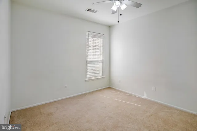 an empty room with a chandelier fan