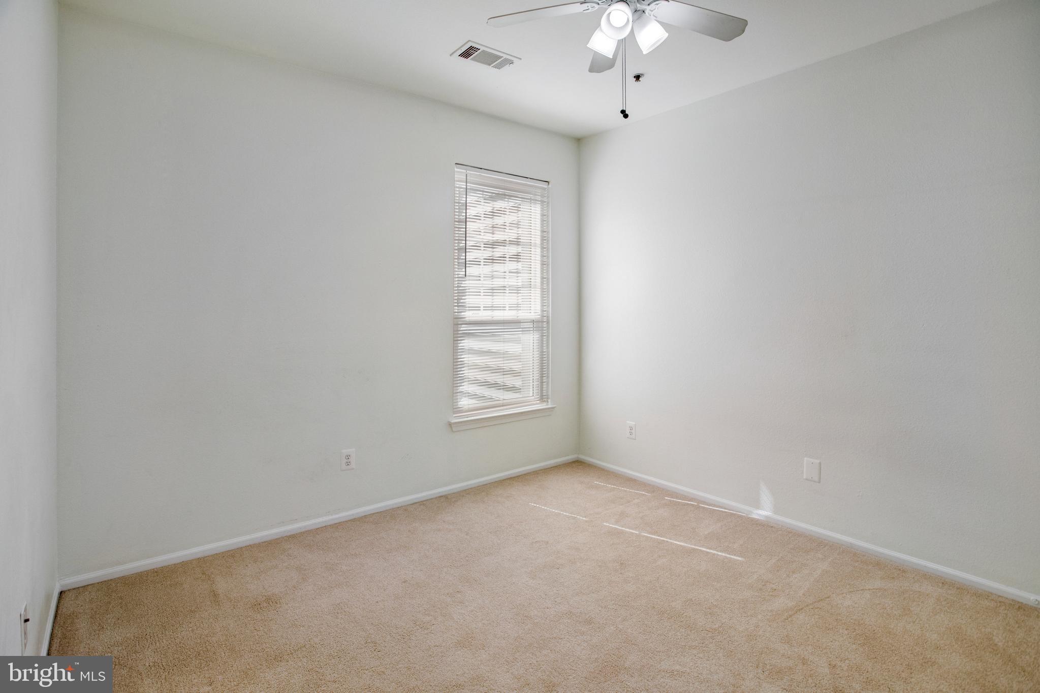 1530 Spring Gate Dr., Unit 9308 McLean, VA 22102 - Photo 24 of 38 an empty room with a chandelier fan and windows