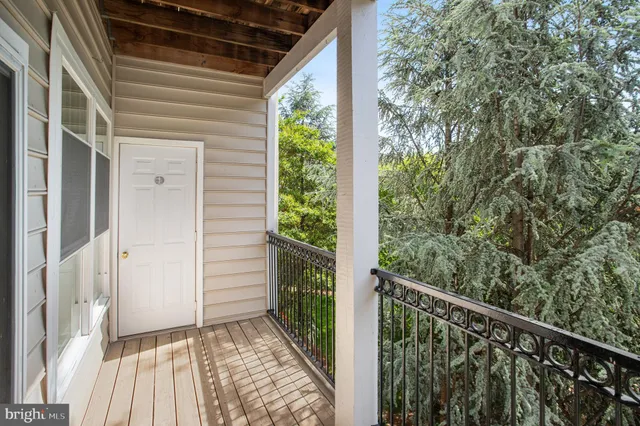 a view of a balcony with wooden floor and fence