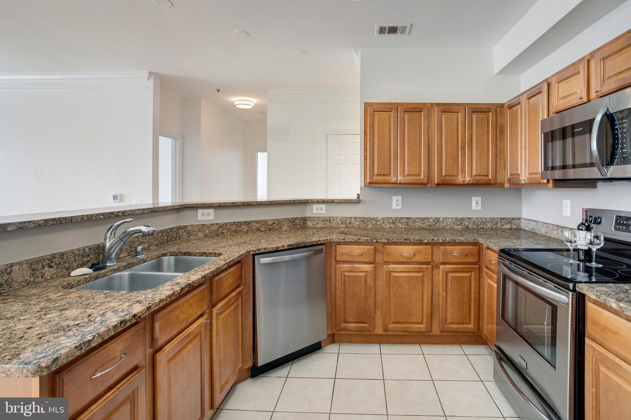 1530 Spring Gate Dr., Unit 9308 McLean, VA 22102 - Photo 10 of 38 a kitchen with stainless steel appliances granite countertop a sink stove and cabinets