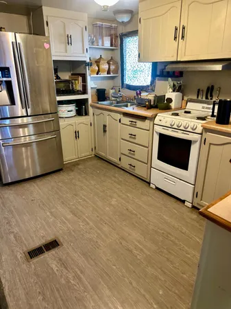 a kitchen with stainless steel appliances a stove a sink and a refrigerator