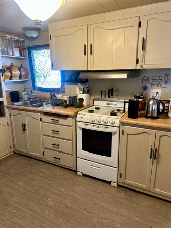 a kitchen with stainless steel appliances granite countertop a stove a sink and a white cabinets