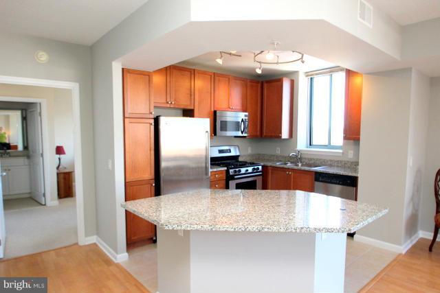 851 North Glebe Road, Unit 1311 Arlington, VA 22203 - Photo 7 of 30 a kitchen with stainless steel appliances granite countertop a sink a stove and a refrigerator
