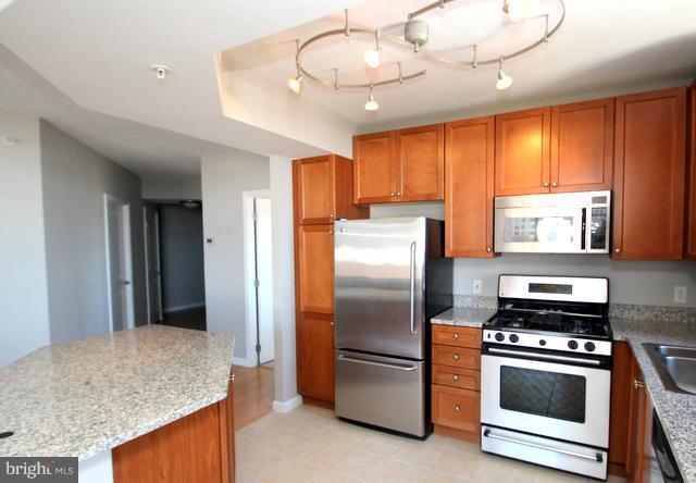 851 North Glebe Road, Unit 1311 Arlington, VA 22203 - Photo 8 of 30 a kitchen with stainless steel appliances granite countertop a refrigerator a stove and a sink with cabinets