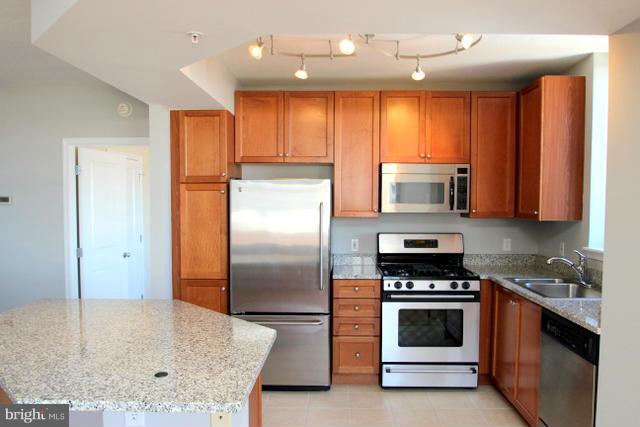 851 North Glebe Road, Unit 1311 Arlington, VA 22203 - Photo 9 of 30 a kitchen with stainless steel appliances granite countertop a stove a sink and a refrigerator