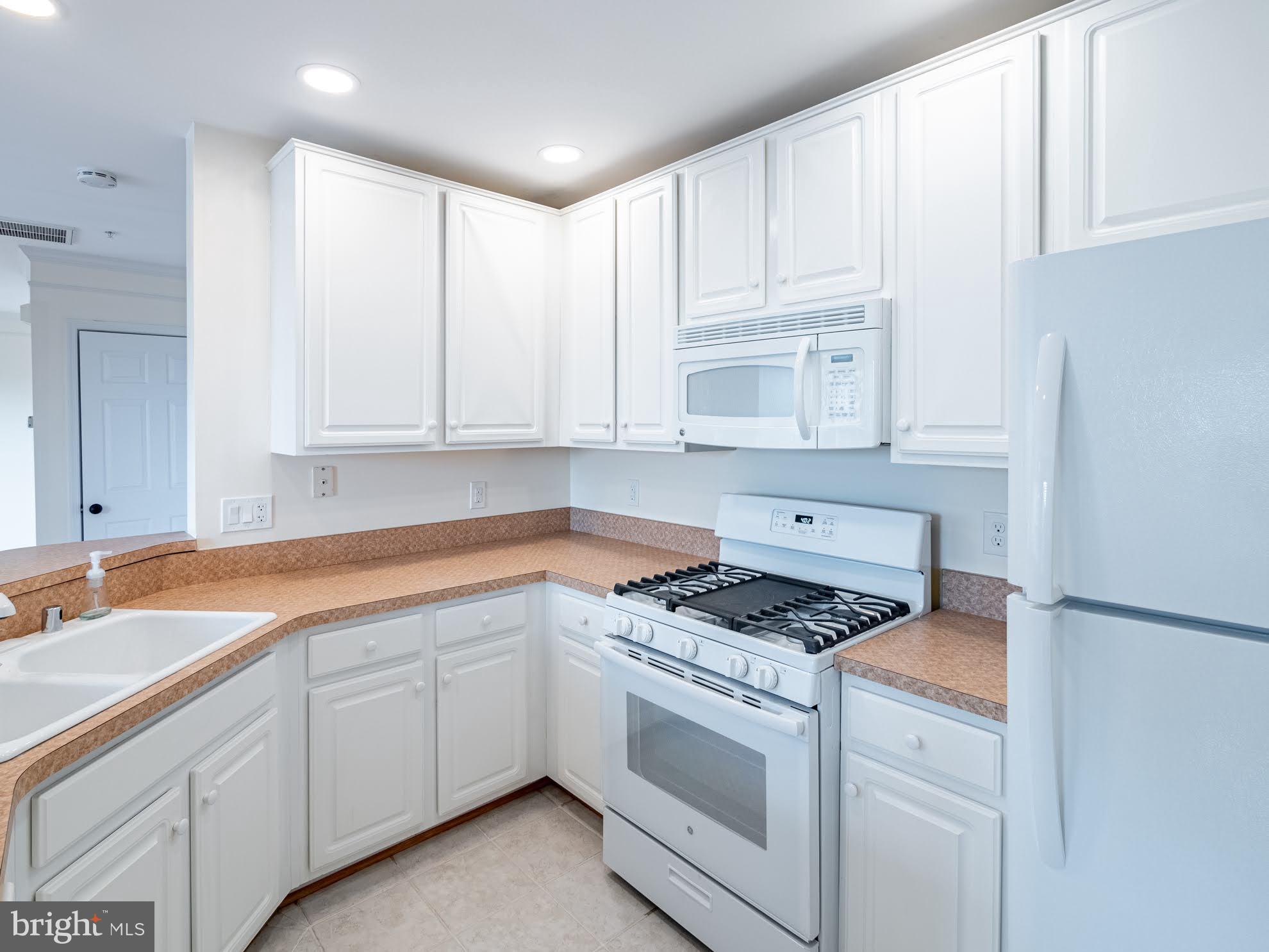 12755 Fair Crest Court, Unit 301 Fairfax, VA 22033 - Photo 6 of 24 a kitchen with granite countertop white cabinets and white appliances