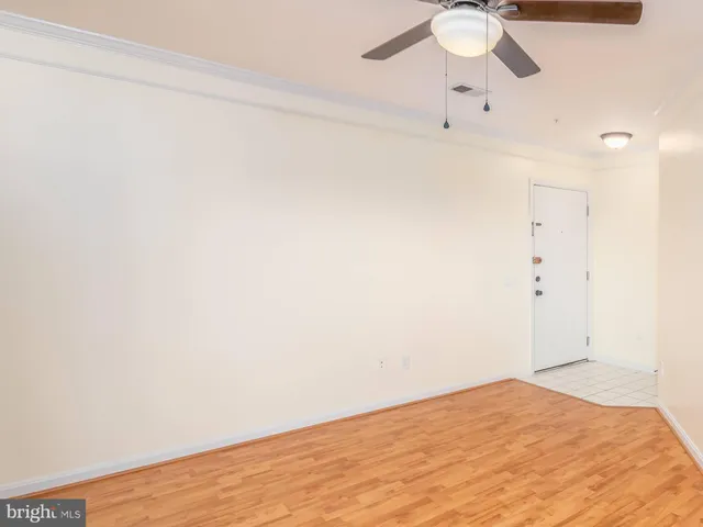 a view of a room with a hanging light and hardwood