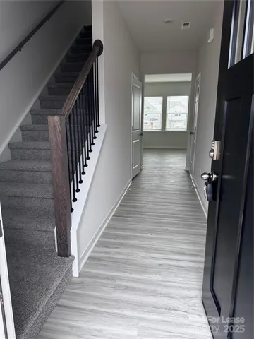 a view of a hallway with wooden floor and staircase