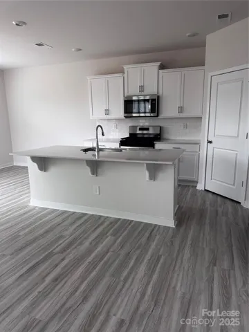 a kitchen with wooden floors and white appliances